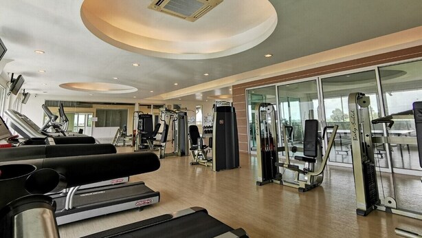 A gym with treadmills, weight machines, and a large mirror. - Suklutai Hotel & Serviced Apartment (Bang Khla)