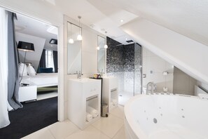A modern bathroom with a large bathtub, a shower area, and a vanity with a mirror. - Vertigo Hotel, Dijon, a Member of Design Hotels (Dijon)
