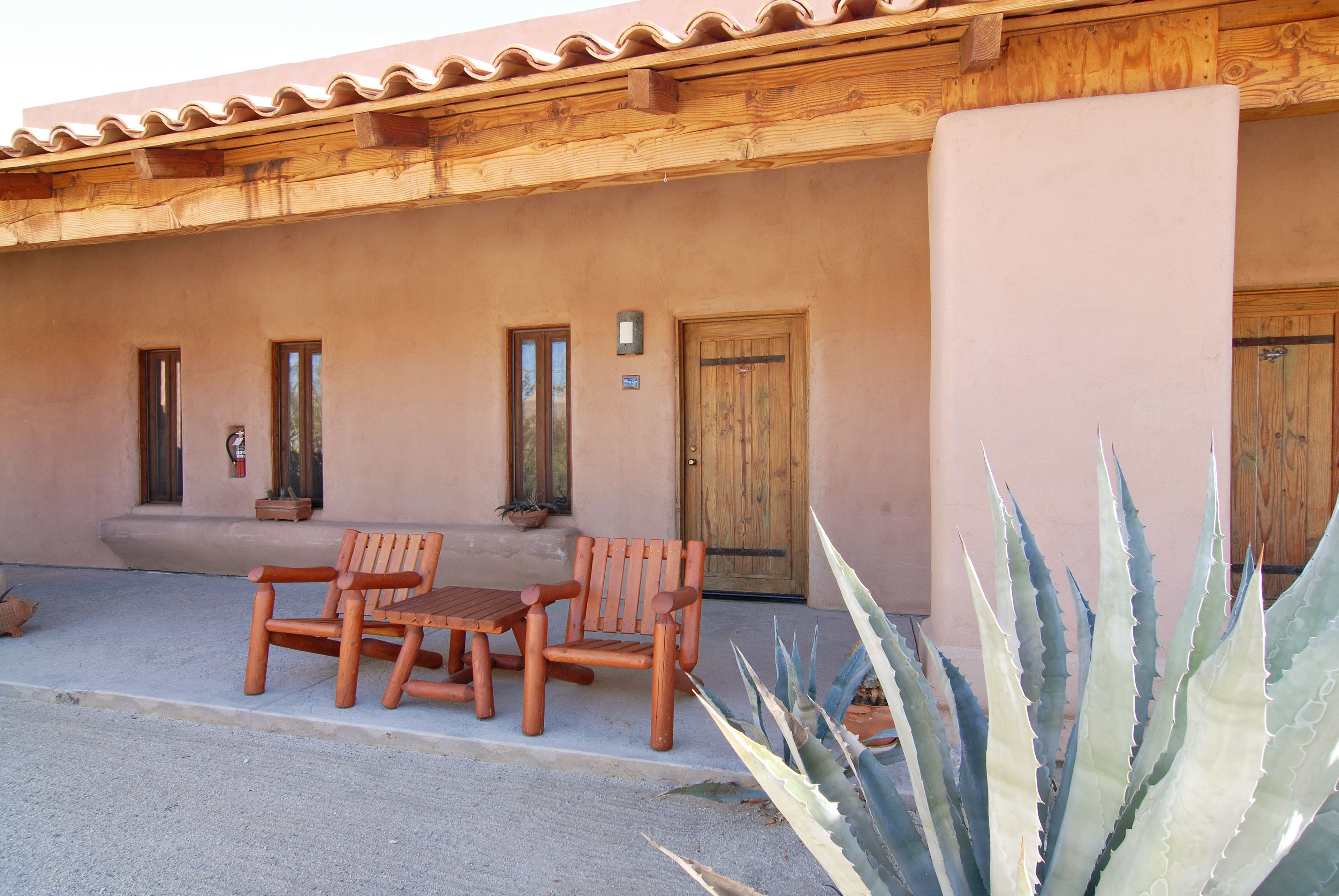 A building with a wooden porch, a wooden door, and a potted plant.