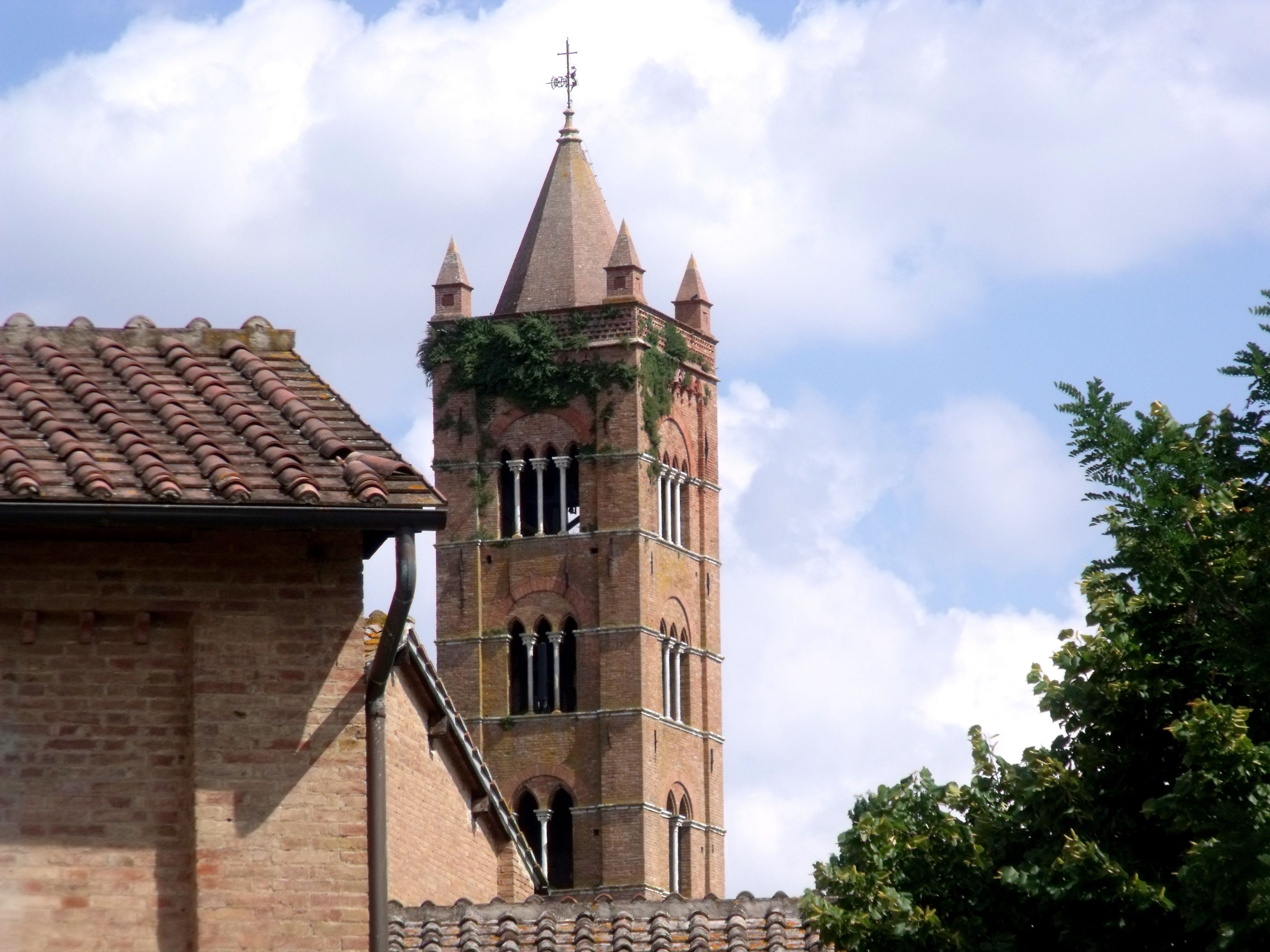 A church with a tall bell tower and a brick facade.