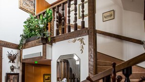 A wooden staircase with a mirror and a plant on the landing. - Park Hotel Turku (Turku)
