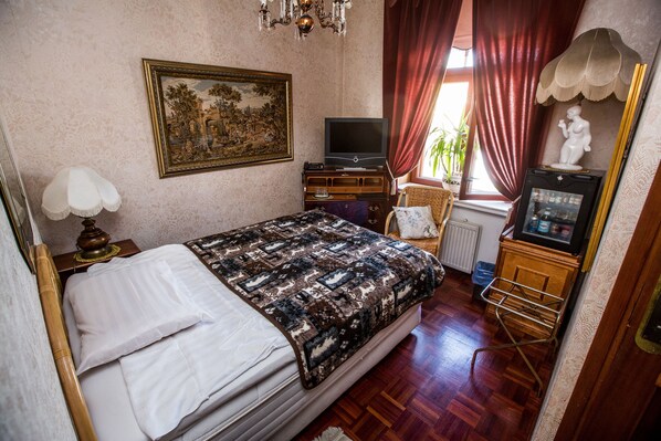 A bedroom with a bed, a television, a dresser, and a chair.