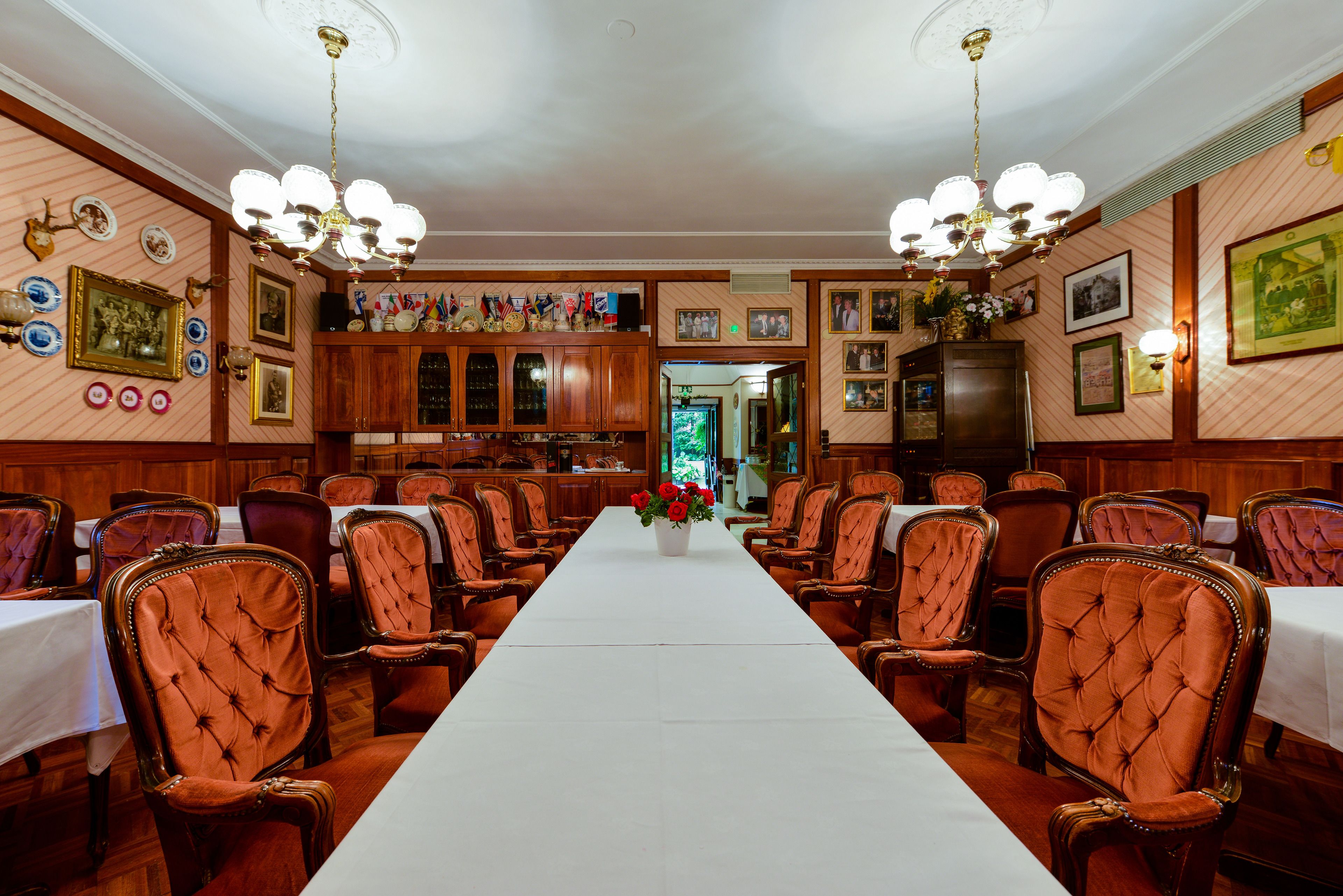A formal dining room with a long table, multiple chairs, and a chandelier.