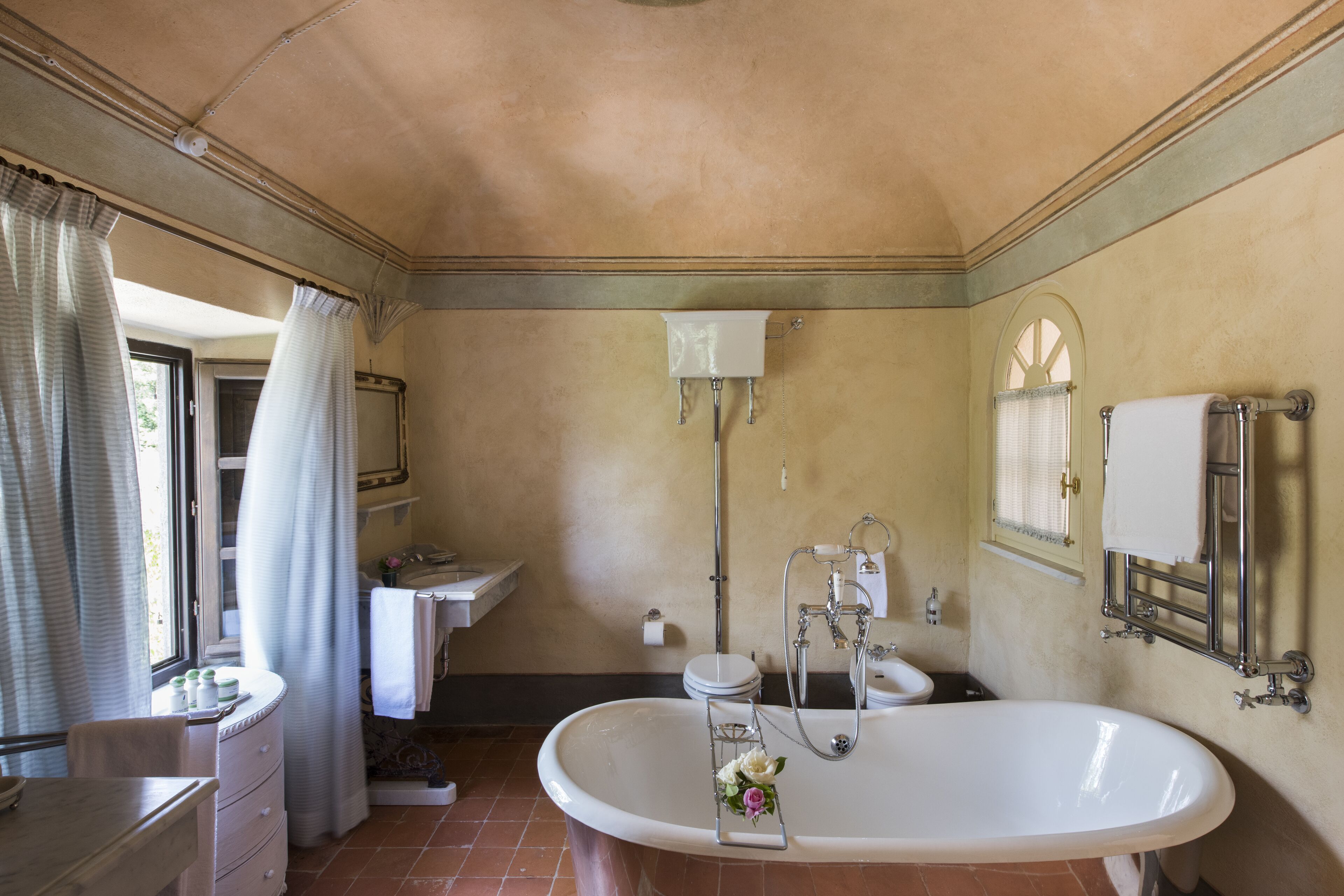 Un bany amb una banyera gran, un lavabo i un vàter.