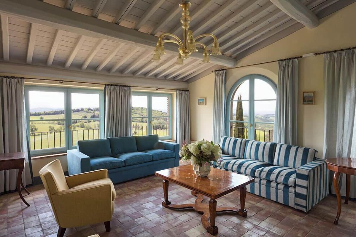 Un salón amplio con techo alto, ventanas grandes y vistas al campo.