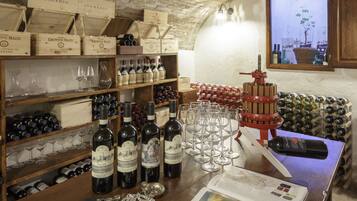 A wine cellar with wooden shelves, wine bottles, and glasses.