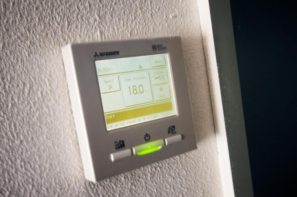 Un thermostat doté d’un écran numérique indiquant une température de 18,0 °C, d’un bouton d’alimentation et d’un bouton de démarrage.