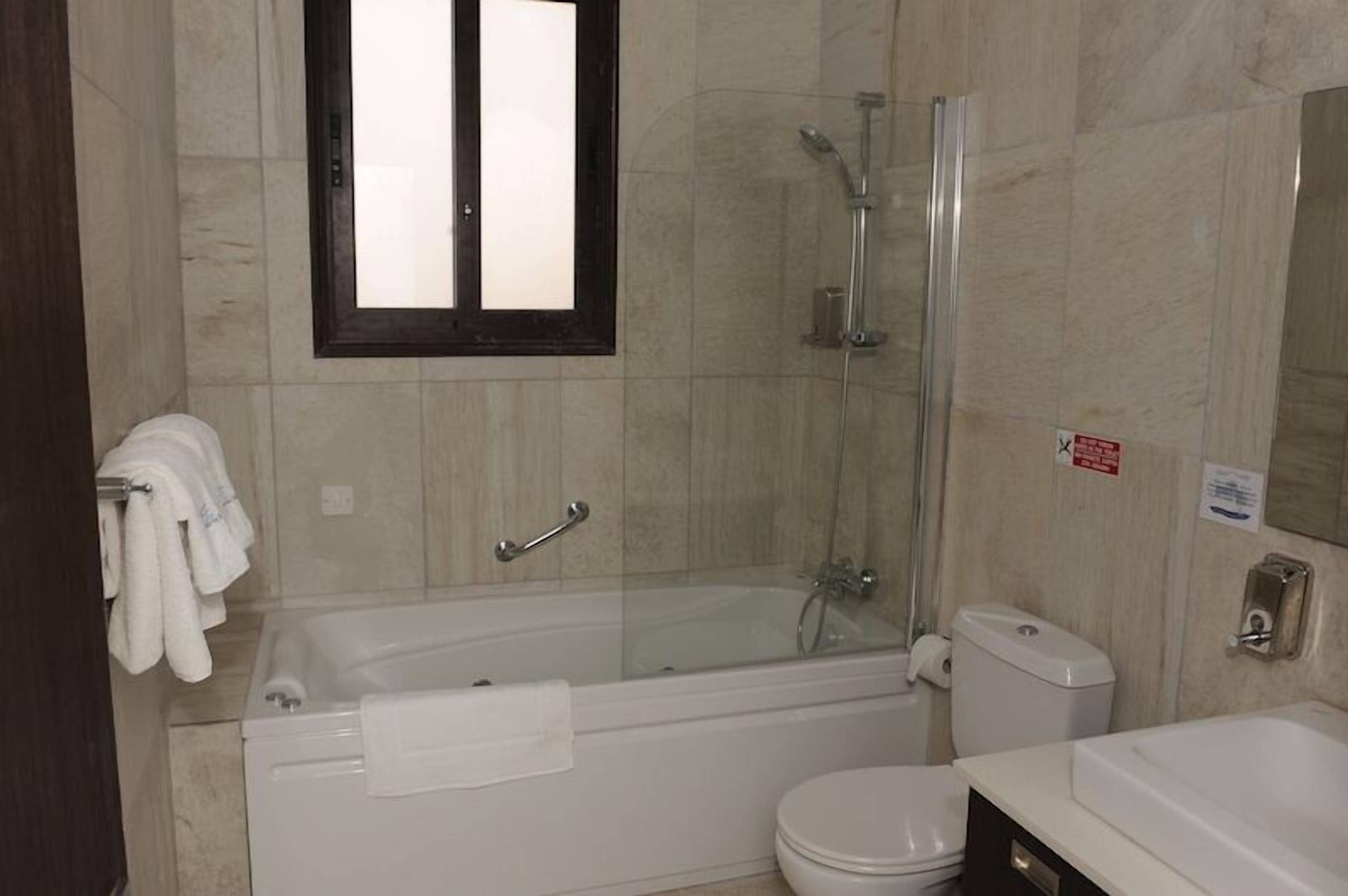 Une salle de bain moderne dotée d’une douche à parois de verre, d’une baignoire et de toilettes.