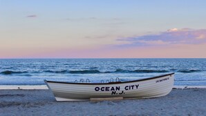 Un vaixell anomenat "Ocean City N.J." a la platja, amb l'oceà al fons.