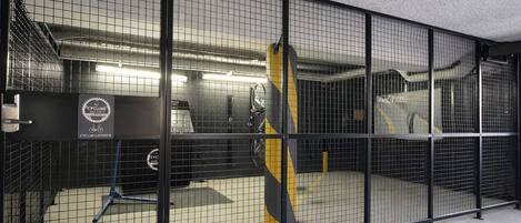 A cycling storage area with a bike rack, a bicycle, and a wall-mounted bike stand.