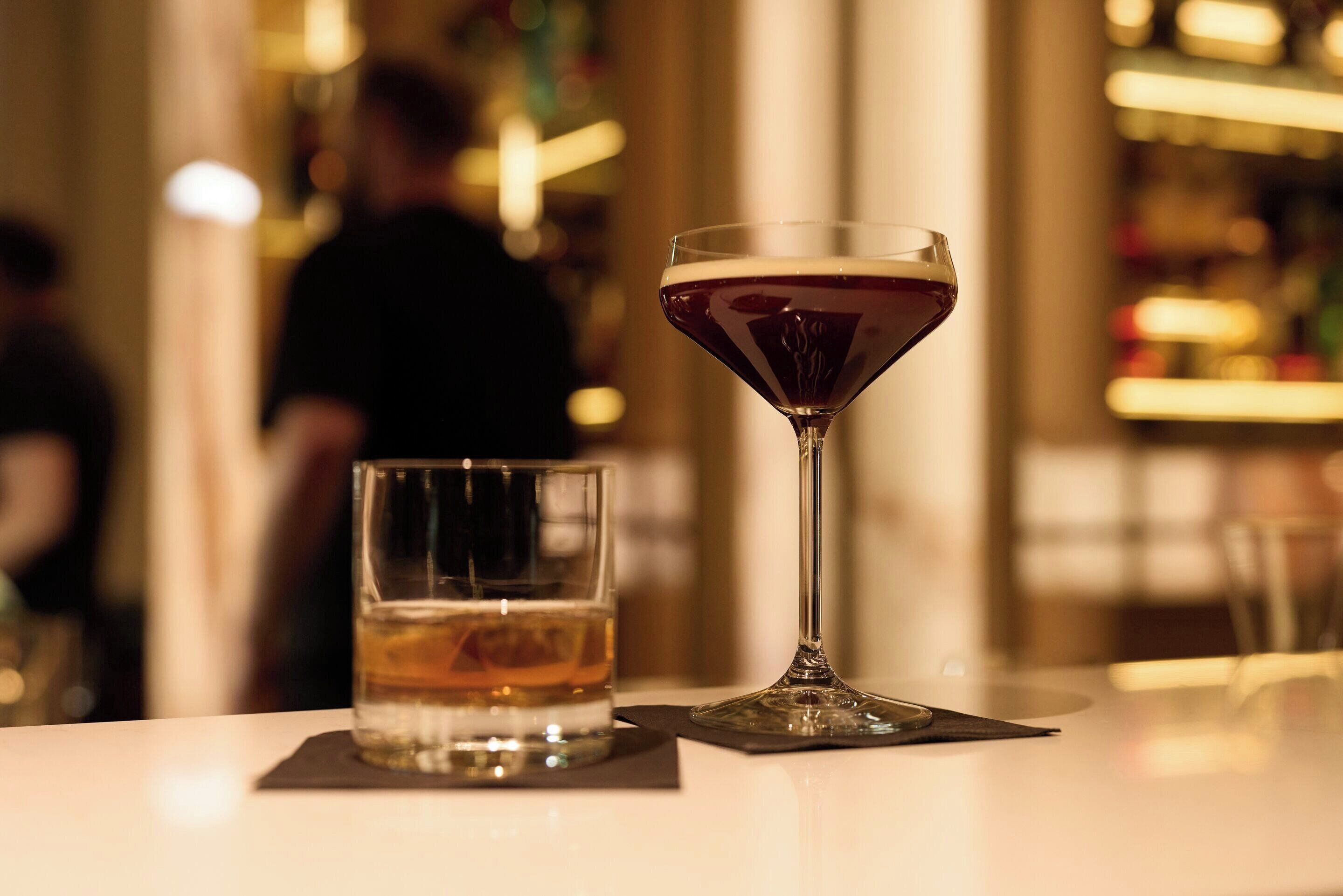 Eine Bar mit einem Martini-Glas und einem kleinen Whiskeyglas.