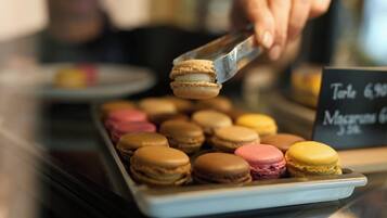 Una bandeja de macarons variados con un cartel que indica los precios.