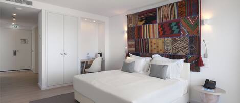 Un dormitorio moderno con una cama grande, un escritorio y un armario.