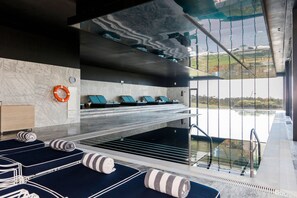 Piscine couverte, piscine extérieure, parasols de plage, chaises longues