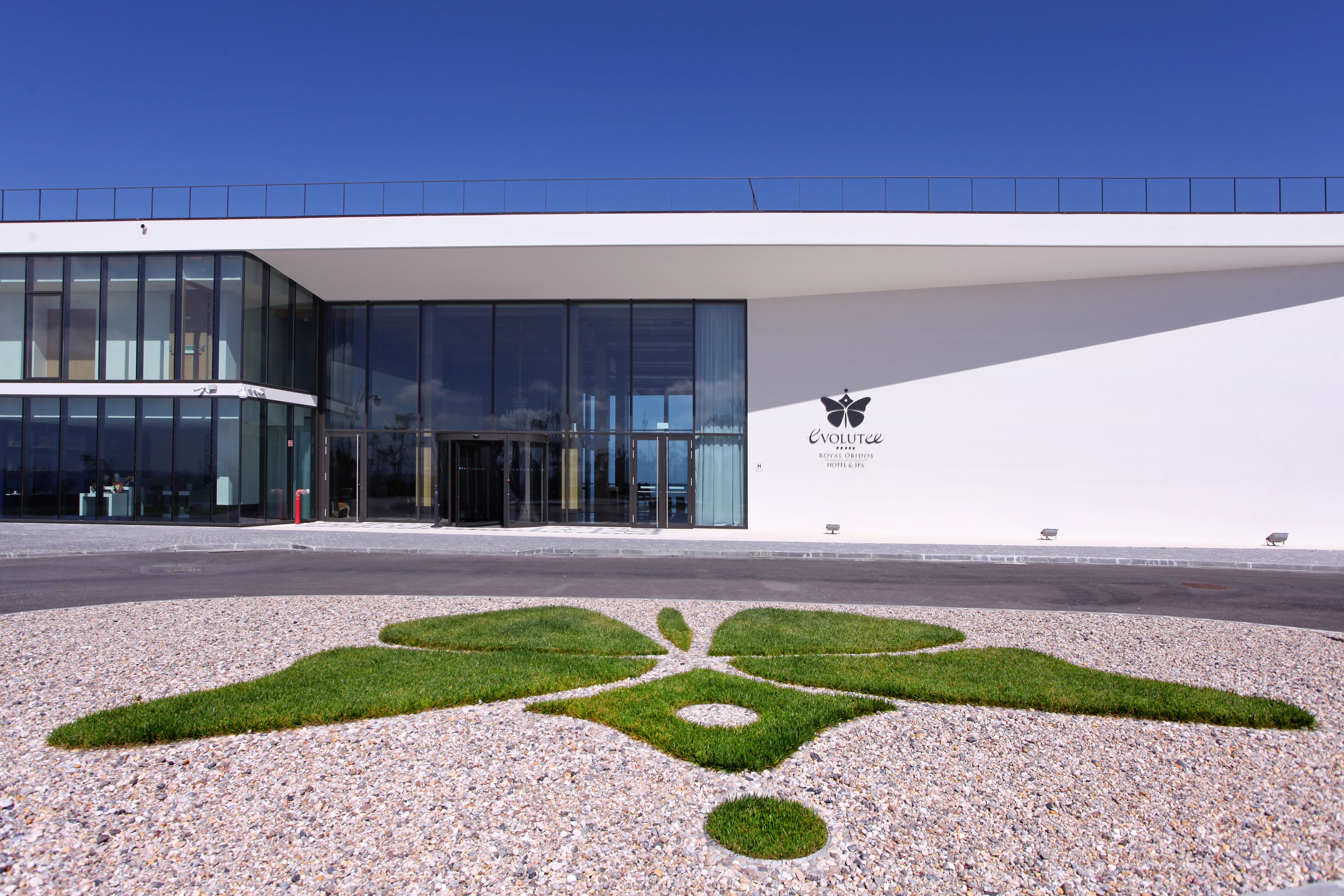 A modern building with large glass windows and a logo on the side.