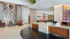 A modern hotel lobby with a reception desk, seating area, and a decorative wall. -  Courtyard by Marriott Ciudad del Carmen Campeche (Ciudad del Carmen)