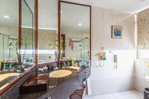 Ein Badezimmer mit zwei Waschbecken, einem großen Spiegel, einer Dusche und einem Handtuchhalter.