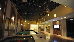 A modern hotel lobby with a central pool, a starry ceiling, and a reception area. - Jinsheng Hotel (Nantong)