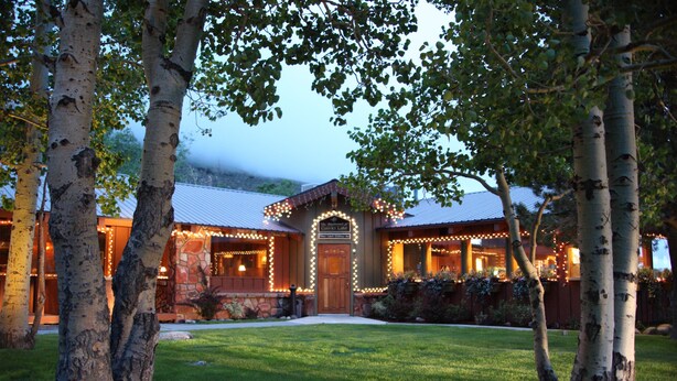 A lodge with a stone facade, a wooden entrance, and a well-maintained lawn. - Convict Lake Resort (Mammoth Lakes)