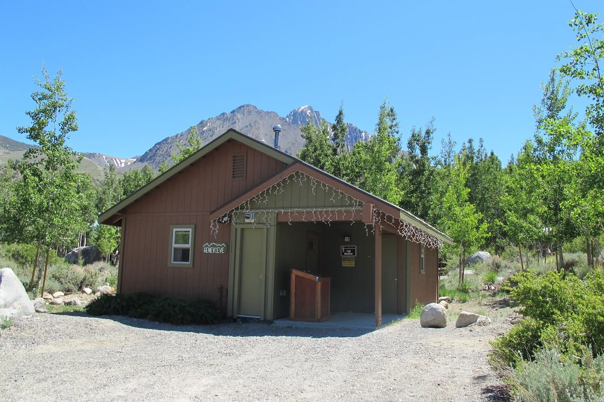 A rustic wooden building with a sign reading "GENEVIEVE".