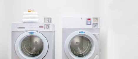 Two front-loading washing machines in a white-walled room.