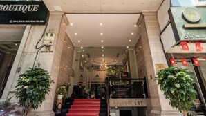 Entrada de hotel con alfombra roja, una escalera y un cartel que dice 'A25 - YOUR HOME'.