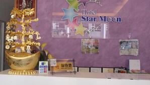 A reception desk at Hotel Star Moon with a decorative golden tree, a star-shaped sign, and a QR code for the Melaka Map. - Hotel Star Moon (Malacca City)
