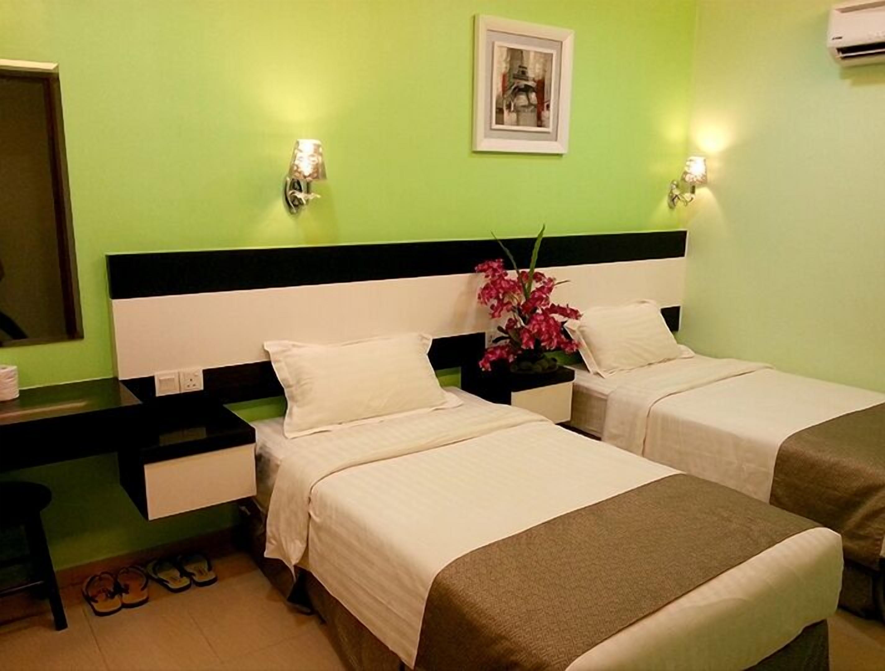 A hotel room with two beds, a nightstand, a mirror, and a picture on the wall.