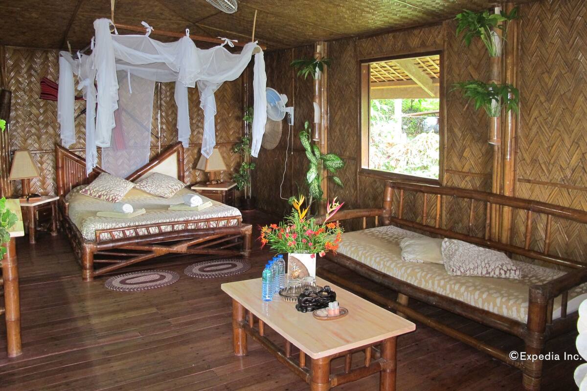 A traditional room with a bed, a sofa, a table, and a window.