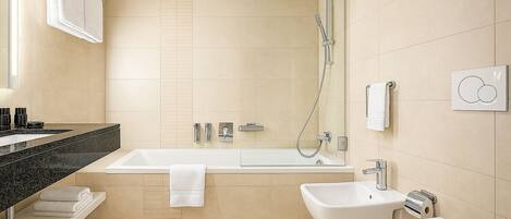 A modern bathroom with a bathtub, a bidet, and a toilet.