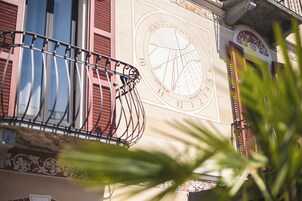 Fachada de edificio con un reloj grande y elementos decorativos.