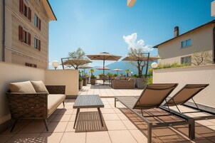 Terraza en la azotea con mobiliario exterior, incluyendo un sofá, sillas y una mesa.