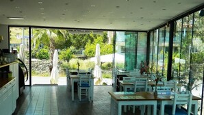 A modern restaurant with a spacious interior, large windows, and outdoor seating. - Liona Hotel (Bodrum)