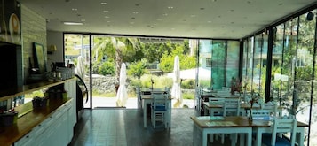 A modern restaurant with a spacious interior, large windows, and outdoor seating.