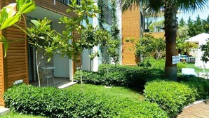 A modern building with a wooden facade, a covered outdoor seating area, and well-maintained greenery. - Liona Hotel (Bodrum)