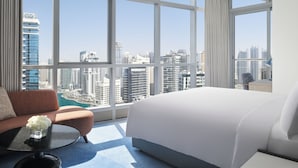 A modern hotel room with a large bed, a sofa, and a coffee table. The room features large windows with a city view. - InterContinental Dubai Marina by IHG (Dubai)