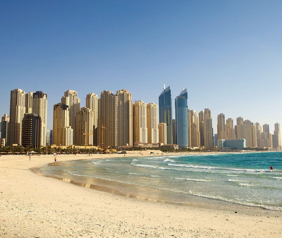 A beach with a city skyline in the background.