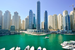 A marina with several boats docked, surrounded by high-rise buildings.