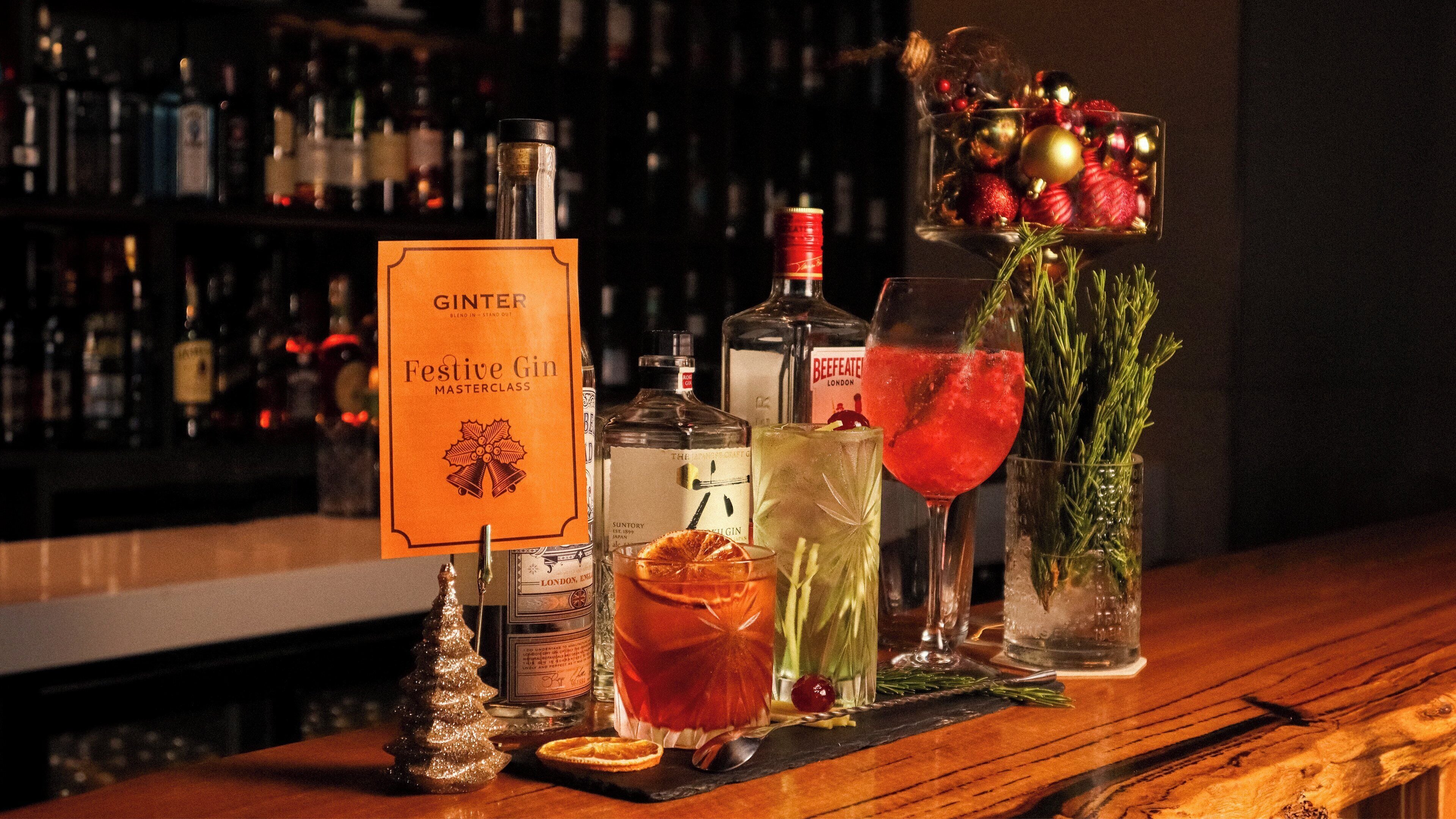 A bar setting with various bottles, a sign for Festive Gin, and a Christmas tree decoration.