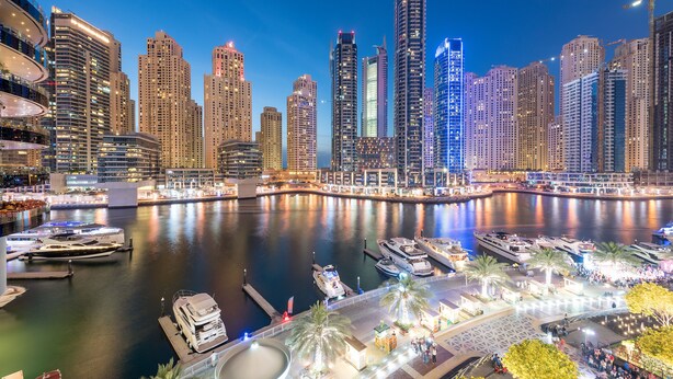 A waterfront cityscape with high-rise buildings, a marina with yachts, and a well-lit promenade. - InterContinental Dubai Marina by IHG (Dubai)