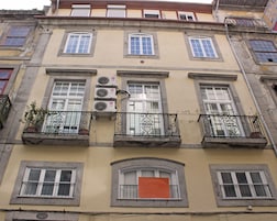 Un edificio de varios pisos con balcones y unidades de aire acondicionado, y un letrero que dice 'SOLD'.