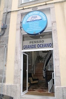 Entrada de hotel con un letrero que dice "PENSÃO GRANDE OCEANO" y "Habitaciones agradables, Good rooms, Buenas habitaciones".