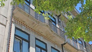 Un edificio con escaparate que dice "VivaCity Porto" y un espacio exterior visible con mesas y sillas.