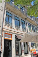 A building with a storefront labeled "VivaCity Porto" and a visible outdoor seating area with a table and chairs.