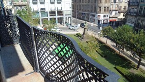 Vista urbana que muestra una calle, edificios y un parque verde.