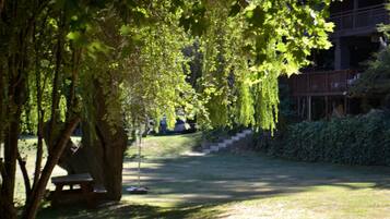 Un parque con una mesa de picnic y un sendero bordeado de árboles.