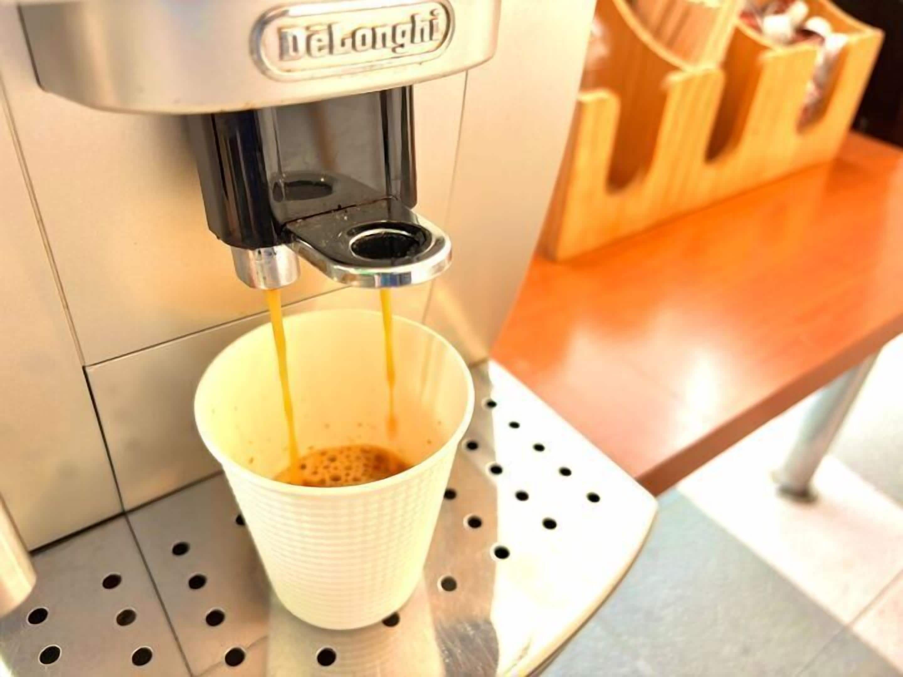 A coffee machine dispensing espresso into a cup.