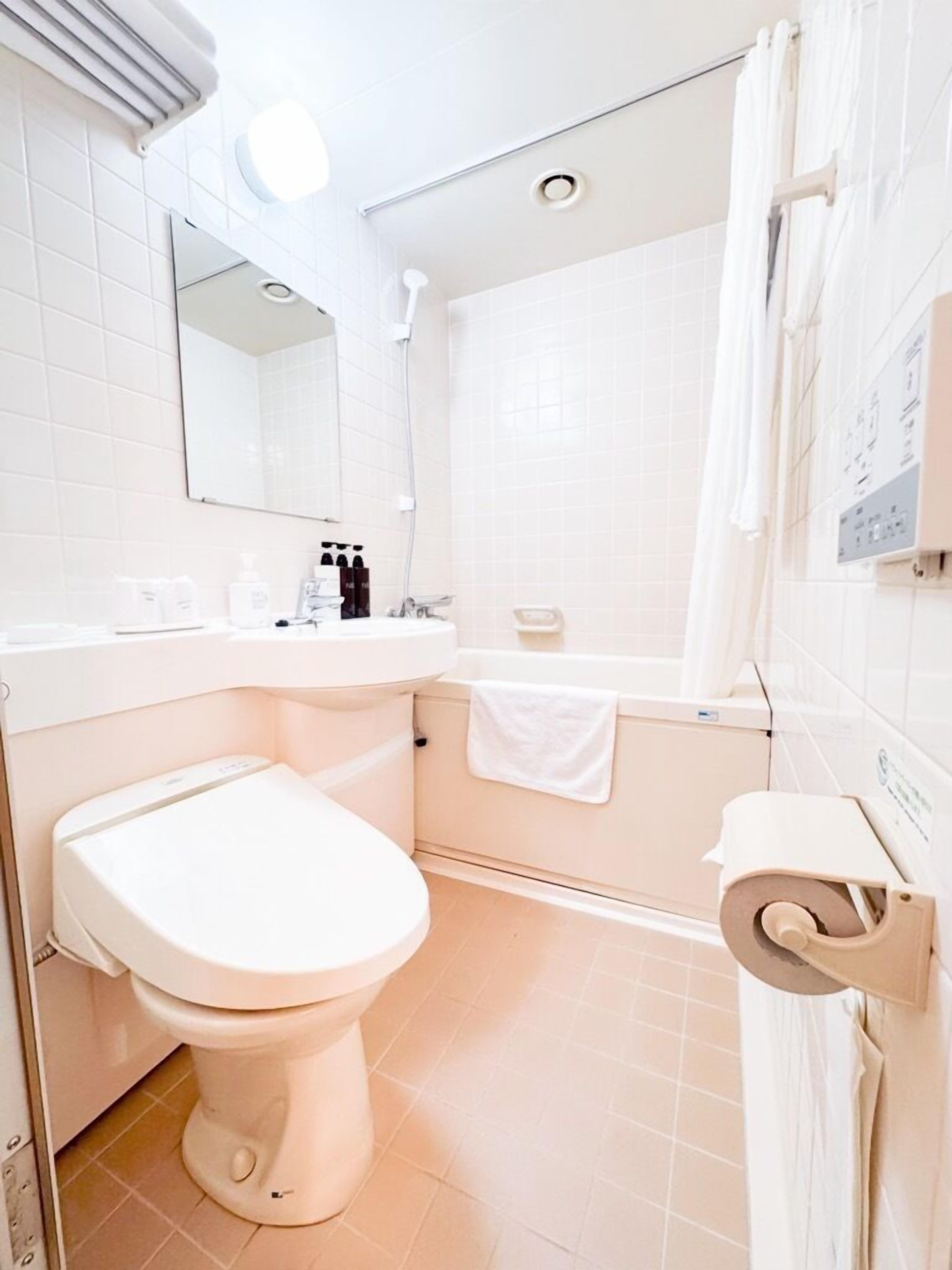 Un baño moderno con inodoro, lavamanos y bañera.