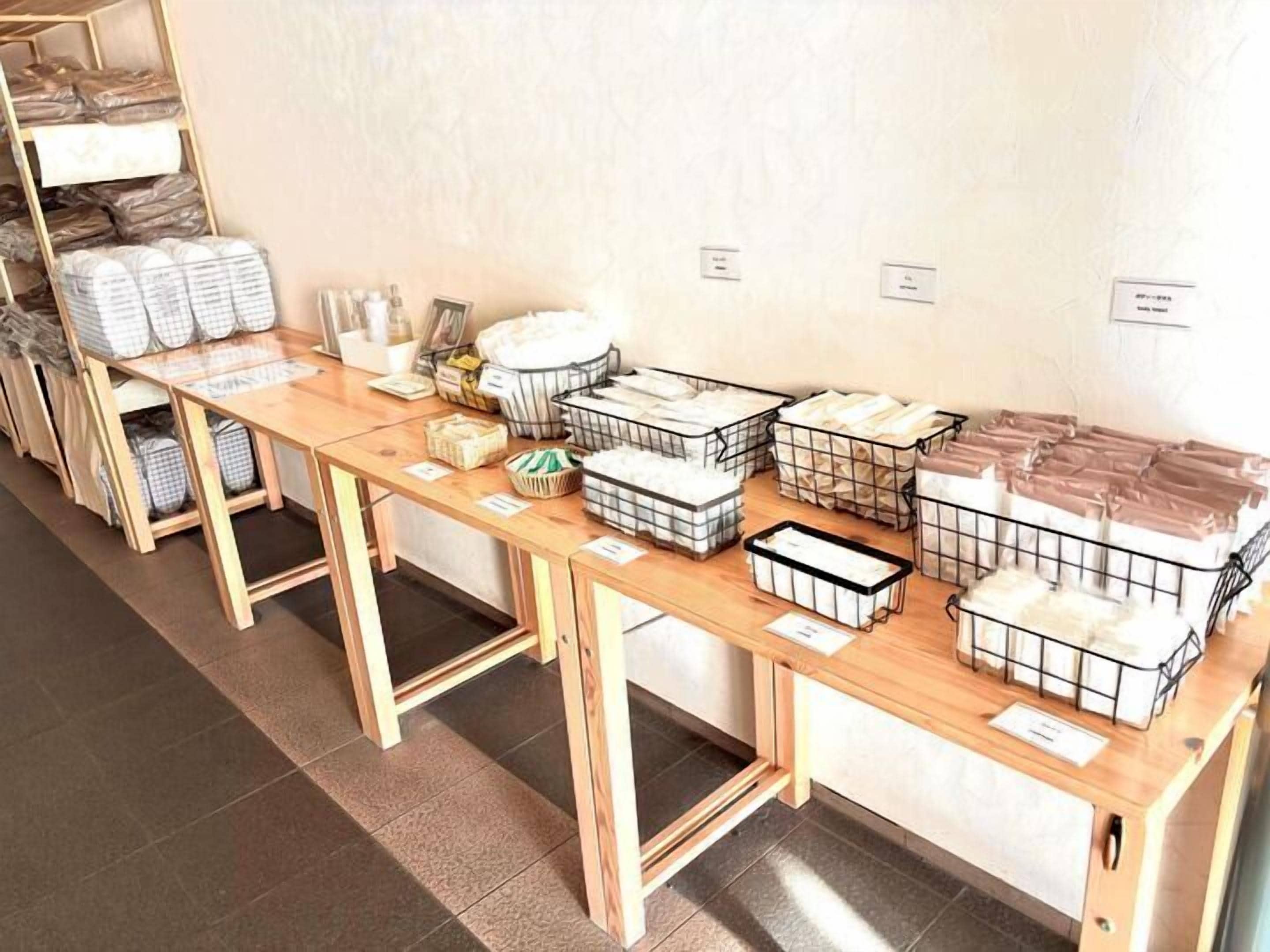 A storage area with wooden tables and metal bins containing various items.
