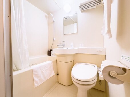 A small, compact bathroom with a toilet, sink, and shower.